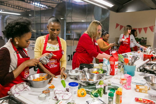 Johannesburg, South Africa - October 05, 2017: Diverse young women learning to cook and bake at a cooking class - Фото, изображение