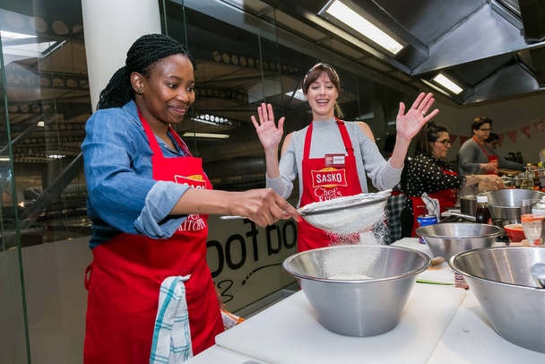 Johannesburg, South Africa - October 05, 2017: Diverse young women learning to cook and bake at a cooking class - Valokuva, kuva