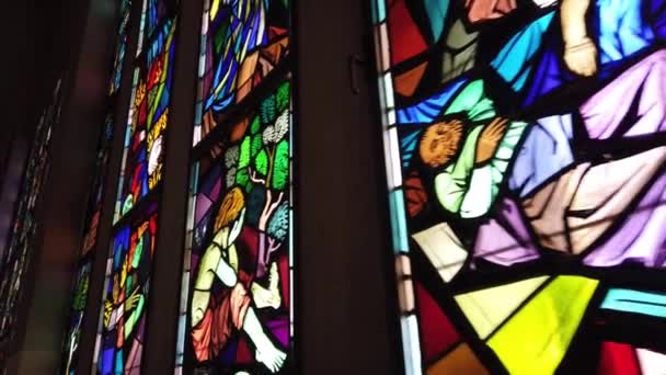 janela de mancha de vidro colorido em uma igreja fundo escuro colorido com cenas de paixão e tristeza
 - Filmagem, Vídeo
