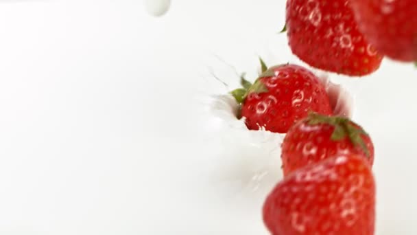 Super slow motion of strawberries falling into milk. Filmed on high speed cinema camera, 1000 fps. - Imágenes, Vídeo
