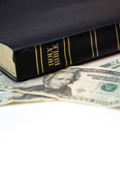 A holy Christian bible with a twenty dollar bill isolated on a white background. - Фото, зображення