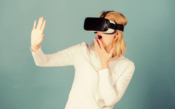 Woman wearing virtual reality goggles. Person with virtual reality helmet isolated on blue background.Woman with virtual reality headset. Virtual reality isolated. - Photo, Image