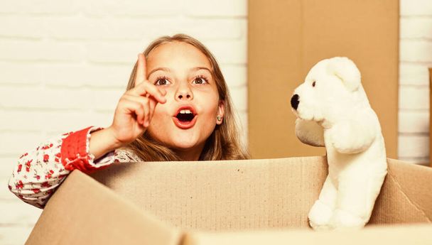 happy little girl with toy. purchase of new habitation. Cardboard boxes - moving to new house. happy child cardboard box. repair of room. new apartment. Dedicated to results - Foto, afbeelding