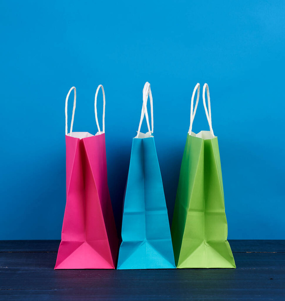 sacchetti di carta multicolore con manico per lo shopping e regali su sfondo blu, primo piano - Foto, immagini