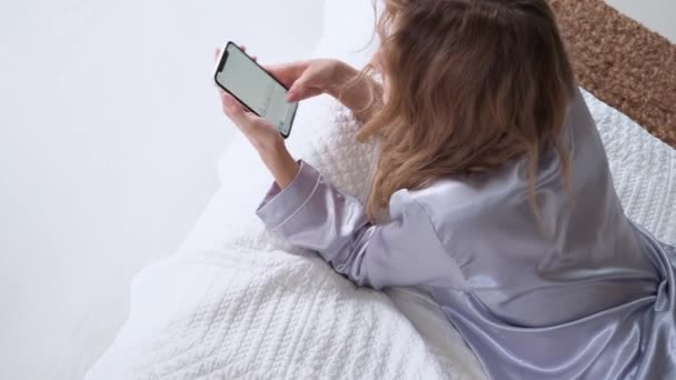 young woman uses a smartphone, communicating in the instant messengers and use the mobile app - Imágenes, Vídeo