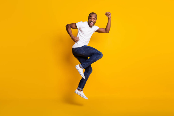 Full length body size view of his he nice attractive glad funny childish cheerful cherry guy jumping having fun dancing isolated over bright vivid shine vibrant yellow color background - Valokuva, kuva