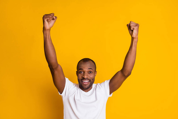 Portrait of his he nice attractive glad cheerful cheery guy rising hands up celebrating sale discount great luck isolated over bright vivid shine vibrant yellow color background - Foto, Imagen
