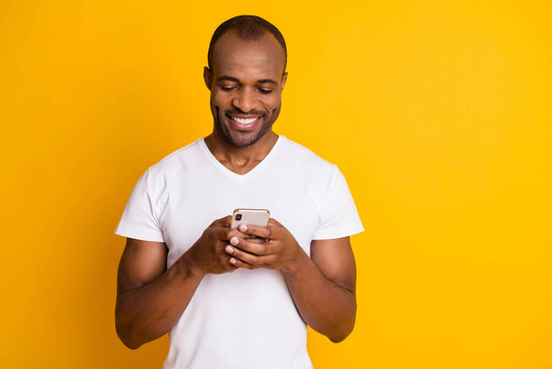 Close-up portrait of his he nice attractive focused cheerful cheery guy using digital device chatting date service isolated over bright vivid shine vibrant yellow color background - Fotoğraf, Görsel