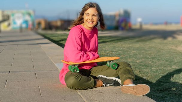 Beautiful young woman with a skateboard - Фото, изображение