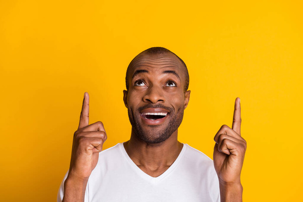 Close up photo of astonished crazy afro american guy indicate incredible ads sales discount point index finger copyspace wear casual style clothes isolated over bright shine color background - Valokuva, kuva