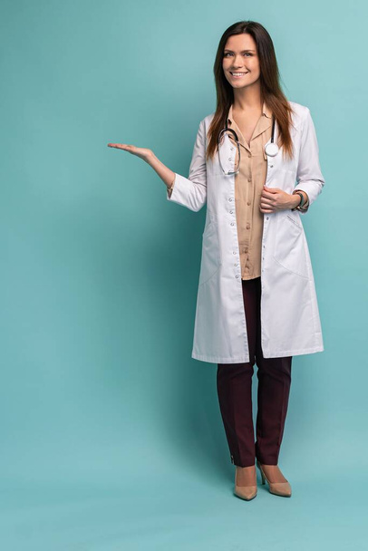 Young medical doctor woman presenting and showing copy space for product or text. Caucasian female medical professional - Foto, Imagen