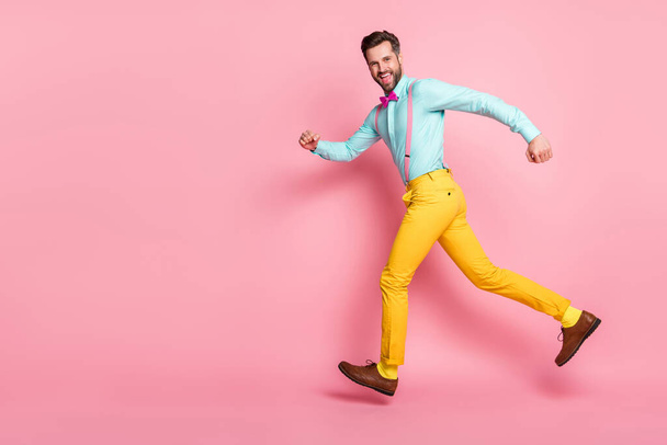Full length photo of cheerful crazy guy enjoy rejoice discount jump run copyspace wear shirt pants isolated over pastel color background - Foto, immagini