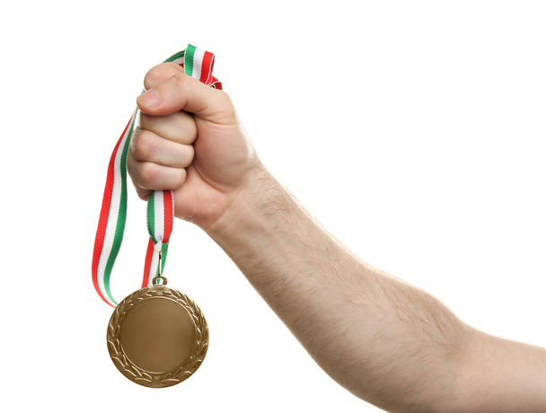 Man holding golden medal on white background, closeup. Space for design - Фото, изображение