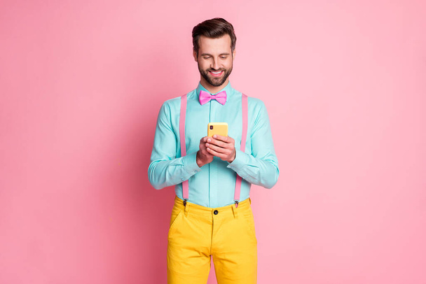 Portrait of his he nice attractive elegant imposing chic classy focused cheerful cheery brunet guy using digital device 5g wi-fi chatting isolated over pink pastel color background - Foto, Imagen