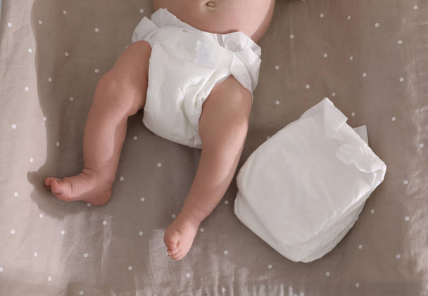 Cute little baby in diaper on changing table, top view - Fotografie, Obrázek