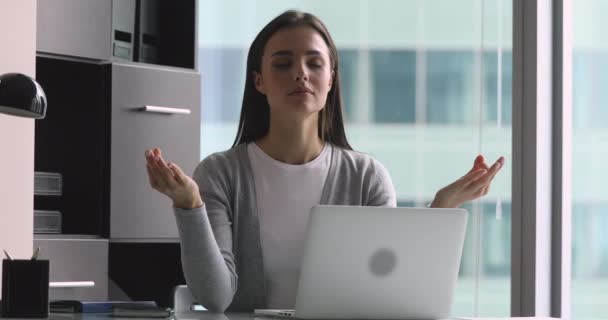 Mindful calm young woman meditate at work with eyes closed - Video