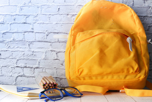 Back to school concept yellow backpack on table  - Valokuva, kuva
