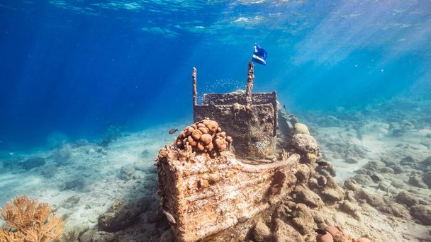 Naufragio "Tugboat" en aguas poco profundas de arrecife de coral en el mar Caribe con Bandera de Curazao, vista a la superficie y rayos de sol - Foto, imagen