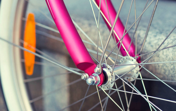 Κοντινό ροζ cruiser πόλης ποδήλατο τροχό μέταλλο ακτίνες και ανακλαστήρα  - Φωτογραφία, εικόνα
