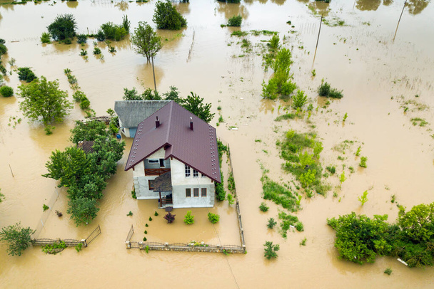 Légi kilátás elárasztott ház piszkos vízzel körülvéve. - Fotó, kép