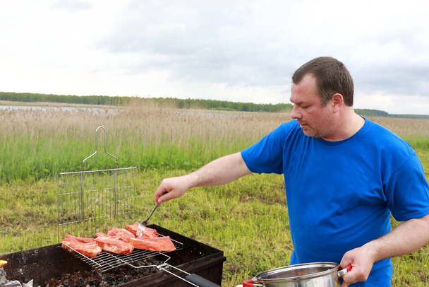 Man cooking marinated pork ribs on grill - Foto, Imagem
