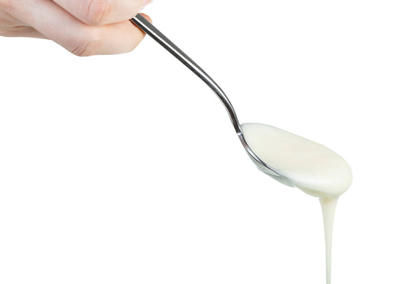 vista lateral de miel blanca orgánica natural vertiendo de cuchara de acero aislada sobre fondo blanco
 - Foto, imagen