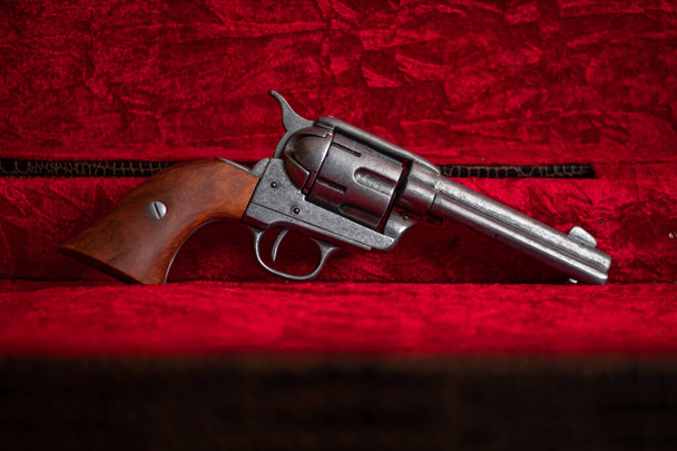 Vecchio revolver selvaggio west con impugnature in legno marrone su velluto rosso - Foto, immagini
