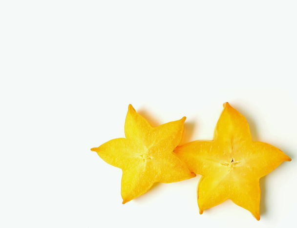 Closed up pair of vibrant yellow sliced ripe Star Fruits on white background, with free space for design and text - Photo, Image