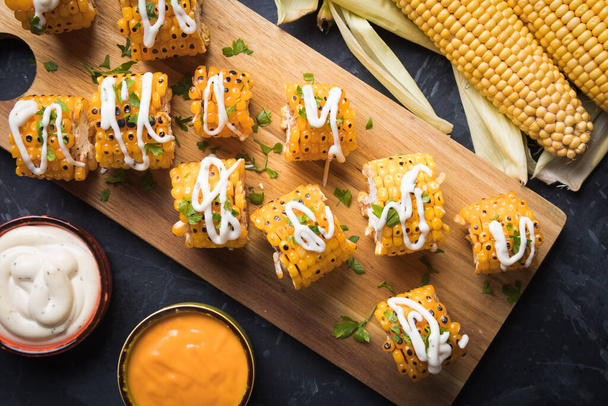 Sweet corn slices grilled and spiced as healthy party food alternative - Foto, afbeelding