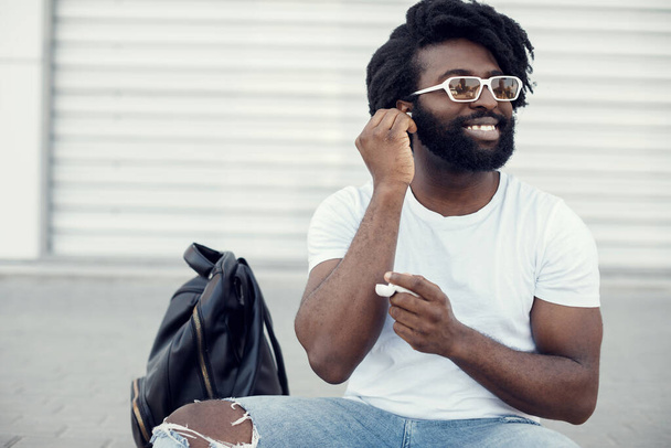 portrait of a handsome happy black man with wireless headphones - Foto, Imagen