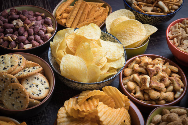 Salty snacks served as party food in ceramic bowls - Photo, image