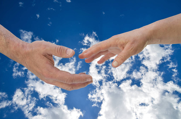 Hetki ennen kosketusta. Miehen ja naisen kädet pilvien edessä. - Valokuva, kuva