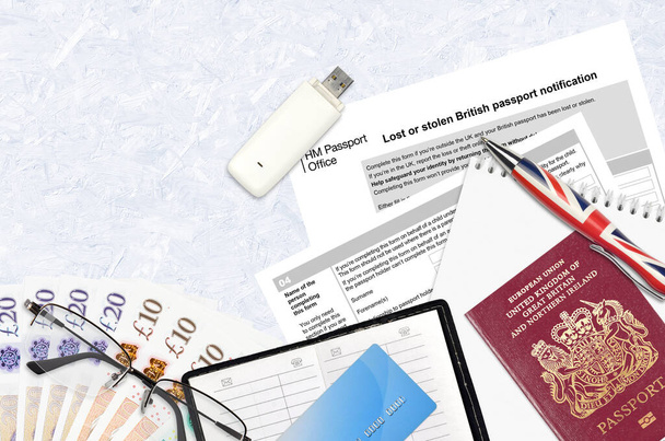 Angol formanyomtatvány LS01 Az elveszett vagy ellopott brit útlevéllel kapcsolatos értesítés a HM útlevélhivataltól az asztalon található irodai tárgyakkal. Egyesült Királyság útlevélpapírmunka - Fotó, kép
