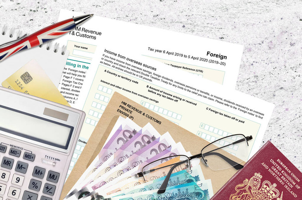 English Tax form sa106 Foreign from HM revenue and customs lies on table with office items. HMRC paperwork and tax paying process in United Kingdom of Great Britain - Photo, Image