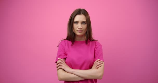 Portrait of young girl posing in studio with pink background - Filmati, video
