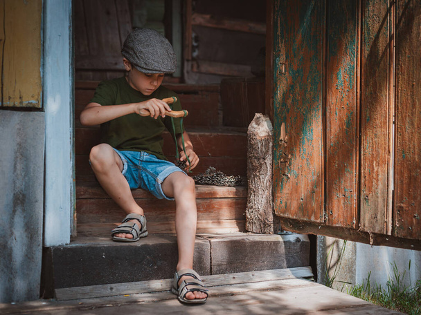 jonge jongen met katapult schieten - Foto, afbeelding