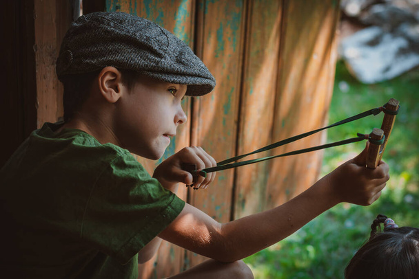 young boy with slingshot shooting - Photo, image