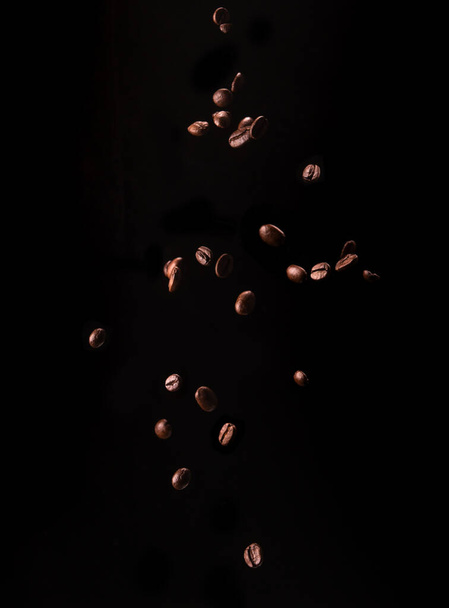 Falling coffee grains on a black background - Fotoğraf, Görsel