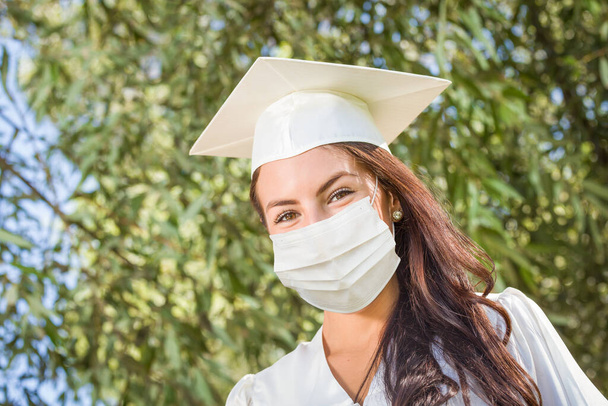 Female Graduate in Cap and Gown Wearing Medical Face Mask. - Φωτογραφία, εικόνα