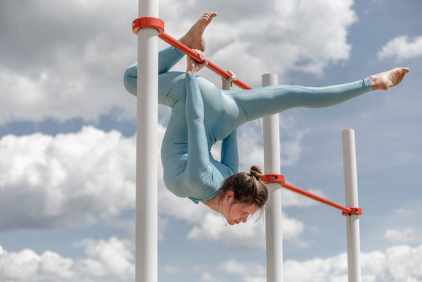 acrobat girl in a blue suit on the street - Fotografie, Obrázek