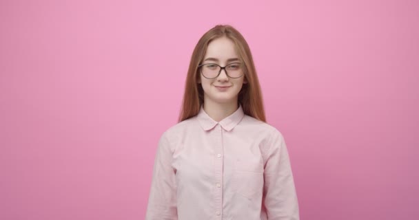 Girl in eyewear and pink shirt smiling and looking at camera - Imágenes, Vídeo