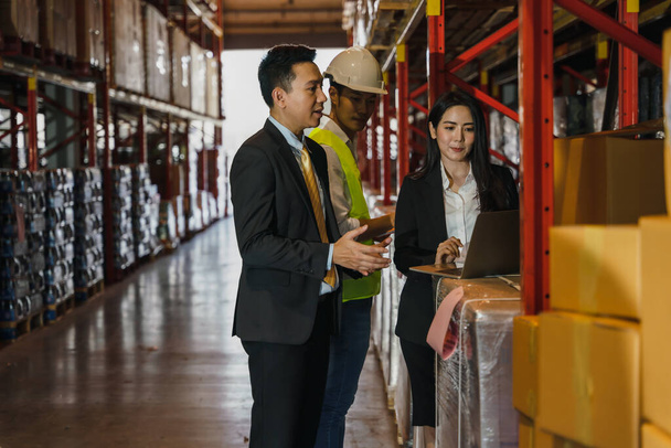 asian business people with factory and warehouse supervisor having business discussion during walking together in storage warehouse - Fotó, kép