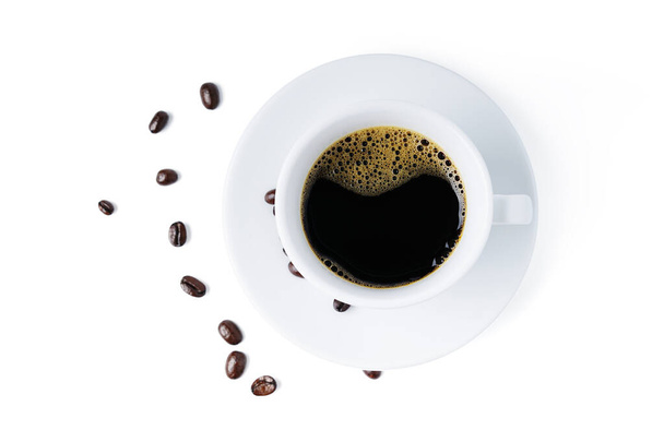 Vue de dessus tasse blanche de café noir avec des grains de café isolés sur fond blanc. chemin de coupe. - Photo, image