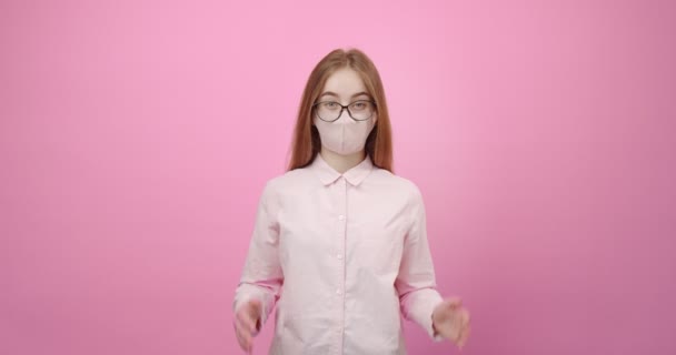 Girl in mask shrugging shoulders and expressing confusion - Кадры, видео