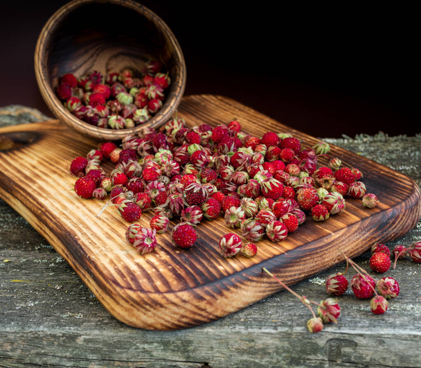 Sweet forest strawberries on a wooden background - Fotoğraf, Görsel
