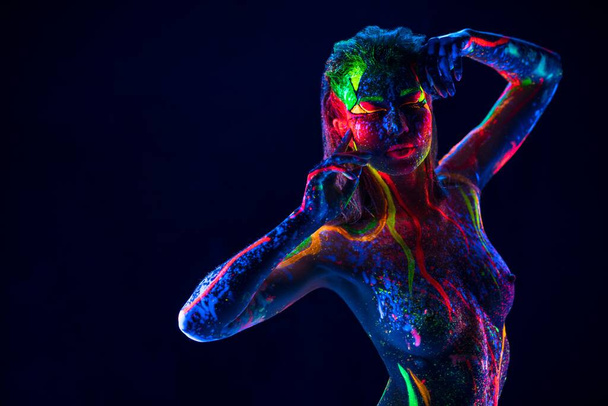 Pretty topless woman with neon ultraviolet body dance in dark - Photo, Image