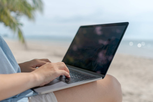 Donna che utilizza laptop e smartphone per studiare in vacanza cady sullo sfondo della spiaggia. Business, finanziario, borsa valori e social network concetto. - Foto, immagini