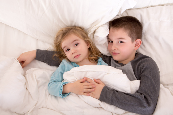 Cariñoso joven hermano y hermana acostado en la cama
 - Foto, imagen