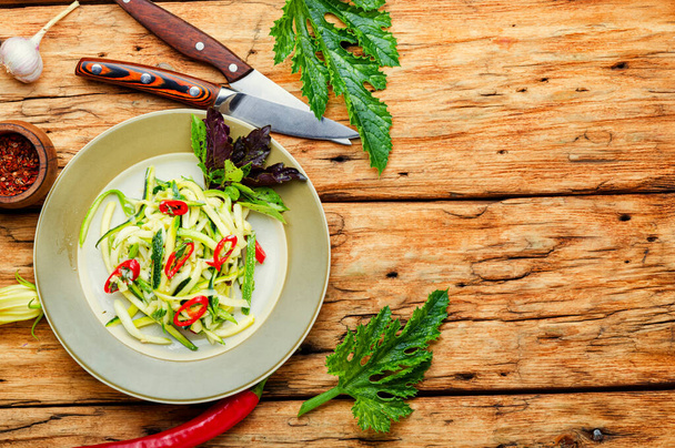 Salade estivale de courgettes fraîches, poivrons, ail et herbes.Nourriture végétarienne sur table rustique en bois. - Photo, image