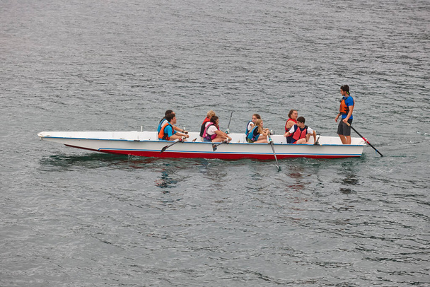 Children learnig to row in the sea. Outdoor effort exercise - Photo, Image